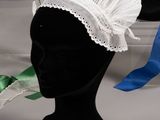a white hat with a green ribbon on top of it