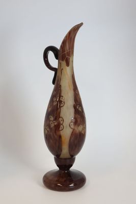 a brown and white vase with a black handle