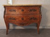 a wooden chest of drawers with a marble top