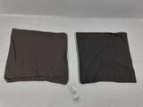 two pieces of clothing are laying on a bed with a remote control