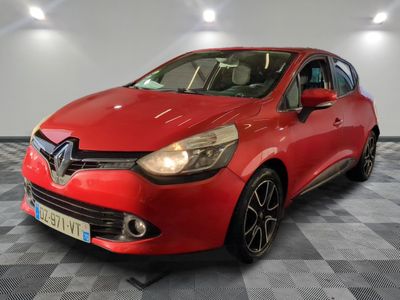 une voiture rouge est garée dans une pièce au sol en damier