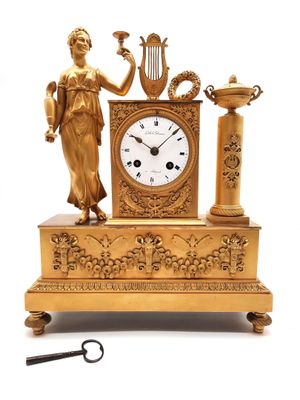 une horloge en or surmontée d'une statue
