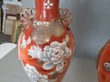 two vases sitting on a table with pictures in the background