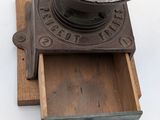 an old coffee grinder sitting on top of a wooden box