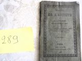 un vieux livre posé sur une table, à côté d'un bout de papier jaune