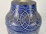 a blue and white vase with a lid on a white surface
