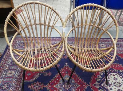une paire de chaises en osier posées sur un tapis, lui-même posé sur le sol