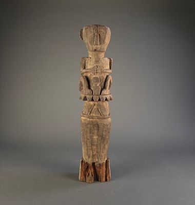une vieille statue en bois représentant une femme avec un oiseau sur l'épaule