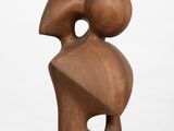 a close up of a wooden sculpture on a white pedestal