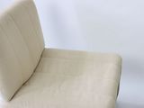 a white chair that has a seat made of fabric