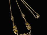 a gold necklace on a black background