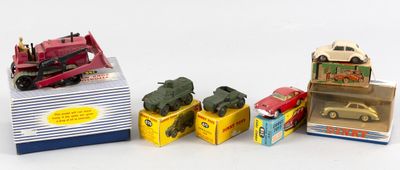 Plusieurs petites voitures et camions sont alignés en rang.