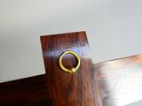 a wooden sign with a brass ring on top of it