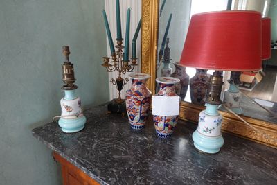 une table sur laquelle se trouvent une lampe, des vases et un miroir