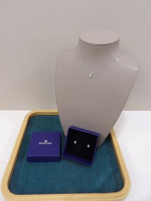 plateau à bijoux violet sur lequel sont posés un collier, des boucles d'oreilles et une bague