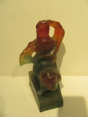 a statue of a man sitting on top of a wooden block