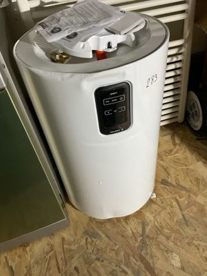 un chauffe-eau posé au sol à côté d'un réfrigérateur