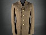 a brown coat on a mannequin stand with a black background