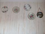 quatre assiettes accrochées au mur, avec un miroir accroché au mur