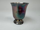 un vase violet et bleu posé sur une table blanche
