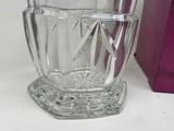 a glass cup sitting on a table next to a purple box