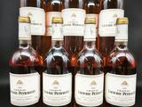 six bouteilles de vin sont alignées sur une surface noire
