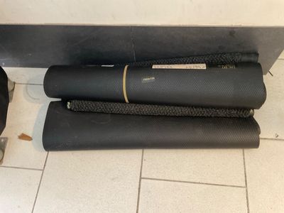 three black yoga mats on the floor next to a black bag