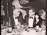 black and white photograph of two men sitting at a table with wine glasses