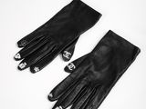 a pair of black leather gloves sitting on top of a white table