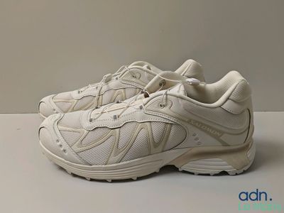 the white sneakers are lined up on a white surface