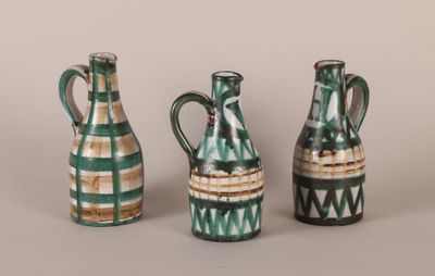 three green and white vases sitting next to each other on a table