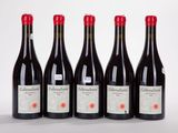 quatre bouteilles de vin sont alignées sur une surface blanche