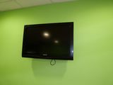 a flat screen tv mounted on the wall in a green room