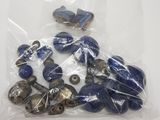 a bag of blue and silver buttons on a white table