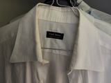 a white shirt hanging on a hanger in a room