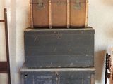 three trunks stacked on top of each other in a room