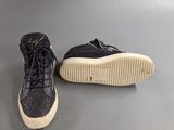 black and white sneakers with laces on them on a gray surface