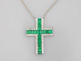 un pendentif en forme de croix, orné d'une émeraude et de diamants