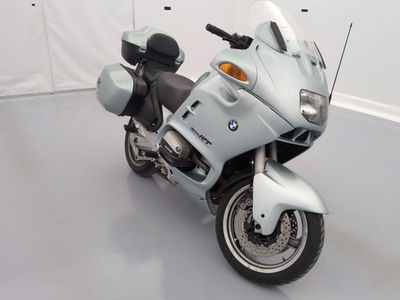 a white motorcycle parked in a room with a white wall