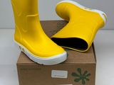 pair of yellow rain boots sitting on top of a cardboard box