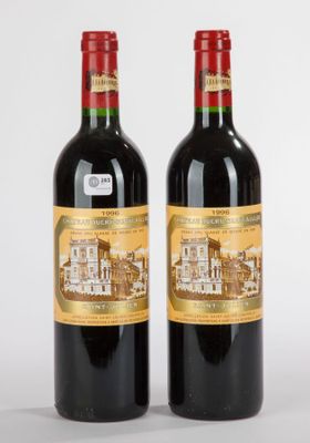 deux bouteilles de vin rouge posées l'une à côté de l'autre sur une surface blanche