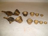 de nombreuses tasses et cuillères en laiton posées sur une table