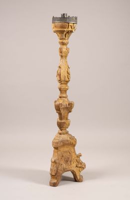 a tall wooden candle holder with a candle on top of it