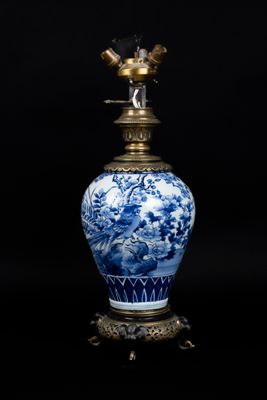 vase bleu et blanc surmonté d'un oiseau, posé sur un socle