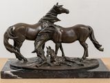 bronze statue of two horses on a marble base on a table