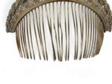 a gold comb that is sitting on a white surface