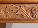 a close up of a carved wood table with drawers