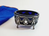 a blue cloth and a silver bowl on a white table