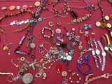 many different types of necklaces and bracelets laid out on a table