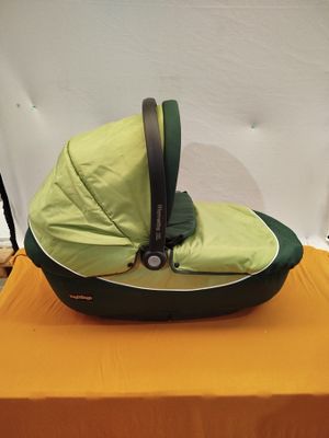 un siège auto pour bébé posé sur une table recouverte d'une nappe jaune